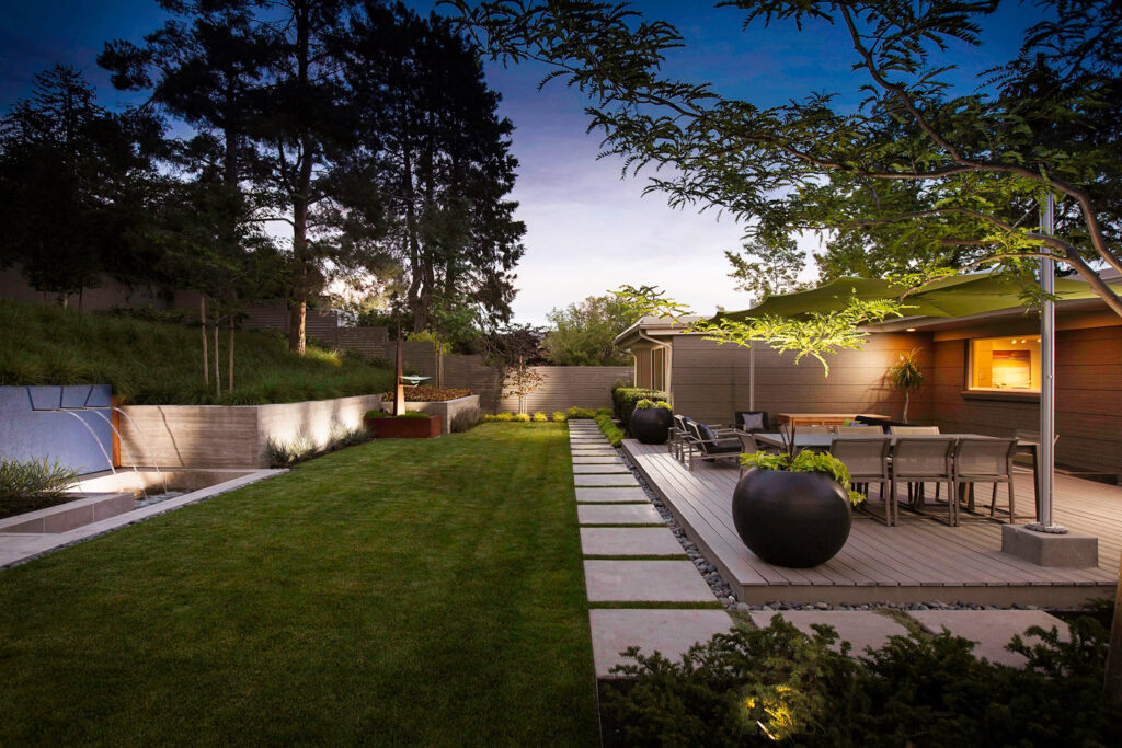 meticulous stunning backyard with water feature and raised patio